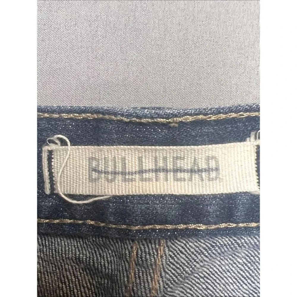 Bullhead denim shorts in a mid to dark blue wash. Rolled hem with cuffed
